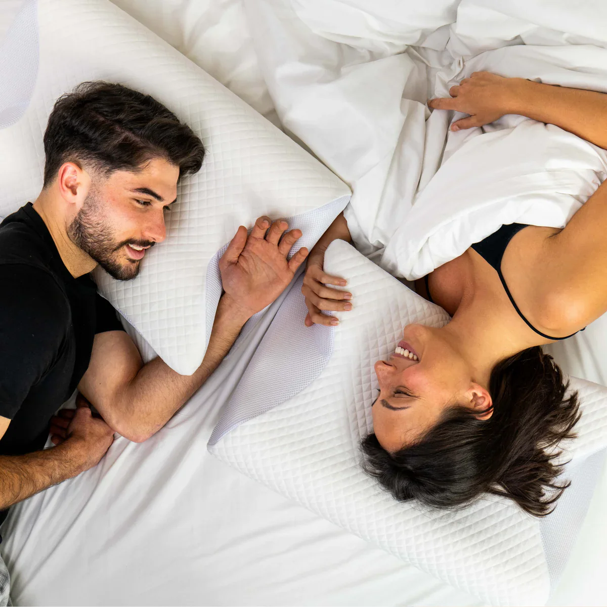 Couple lying on bed using Contour Cloud Ultra-Soft Pillow with white quilted cover for comfort