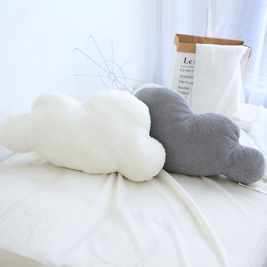 White and gray cloud-shaped throw pillow set by getblissyneck on a bed with soft natural light