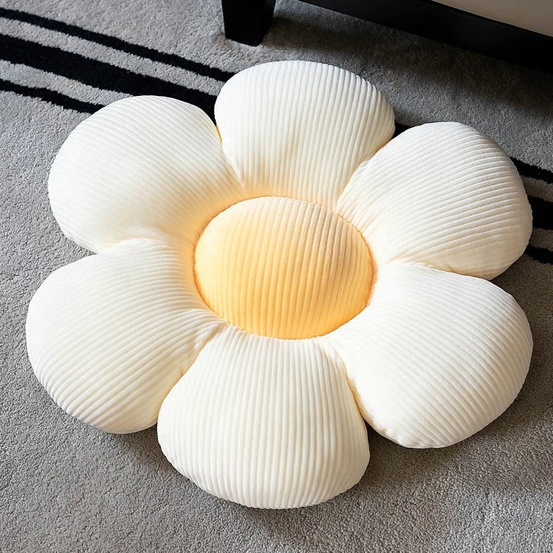 Soft white and yellow flower-shaped throw pillow with textured fabric on carpet