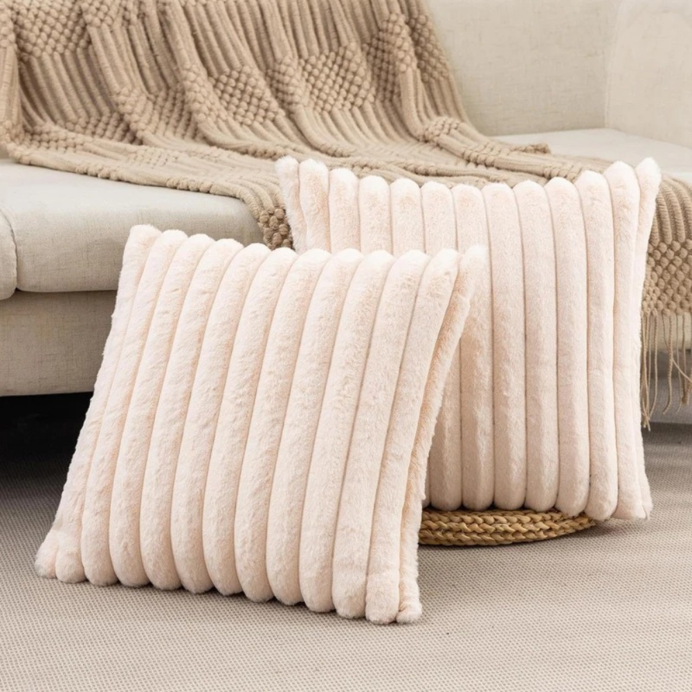 Soft beige fluffy throw pillow with vertical ribbed texture on a cozy living room floor