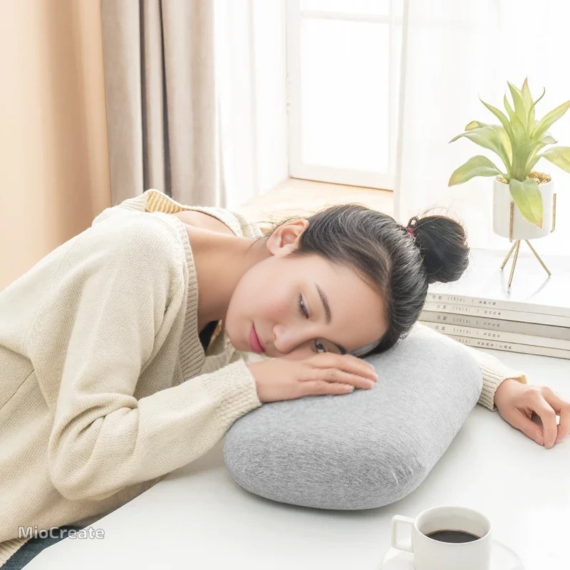 Woman resting head on gray Memory Foam Pillows by getblissyneck with cozy sweater near coffee cup