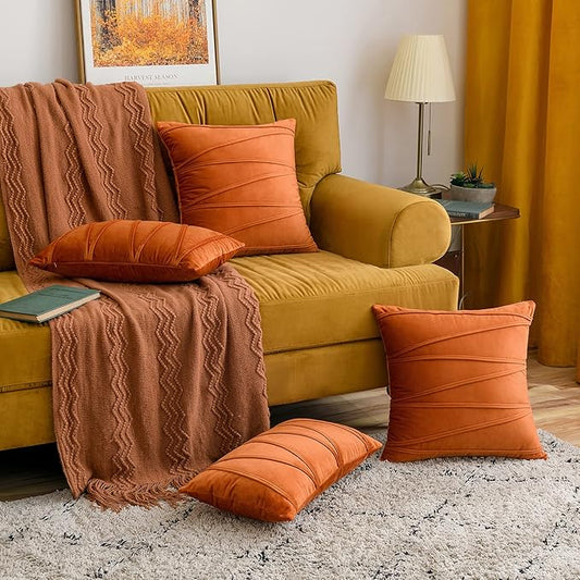 Orange throw pillow cover set on mustard sofa with textured brown throw in cozy living room