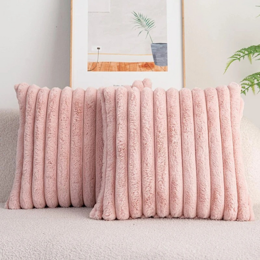 Two soft pink ribbed throw pillow pink case cushions placed on a light-colored sofa