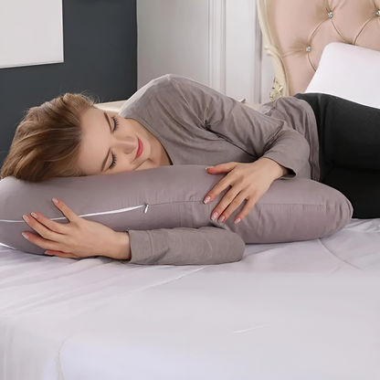 Woman lying on bed hugging a gray Body Shaped Pregnancy Pillow for comfort and support